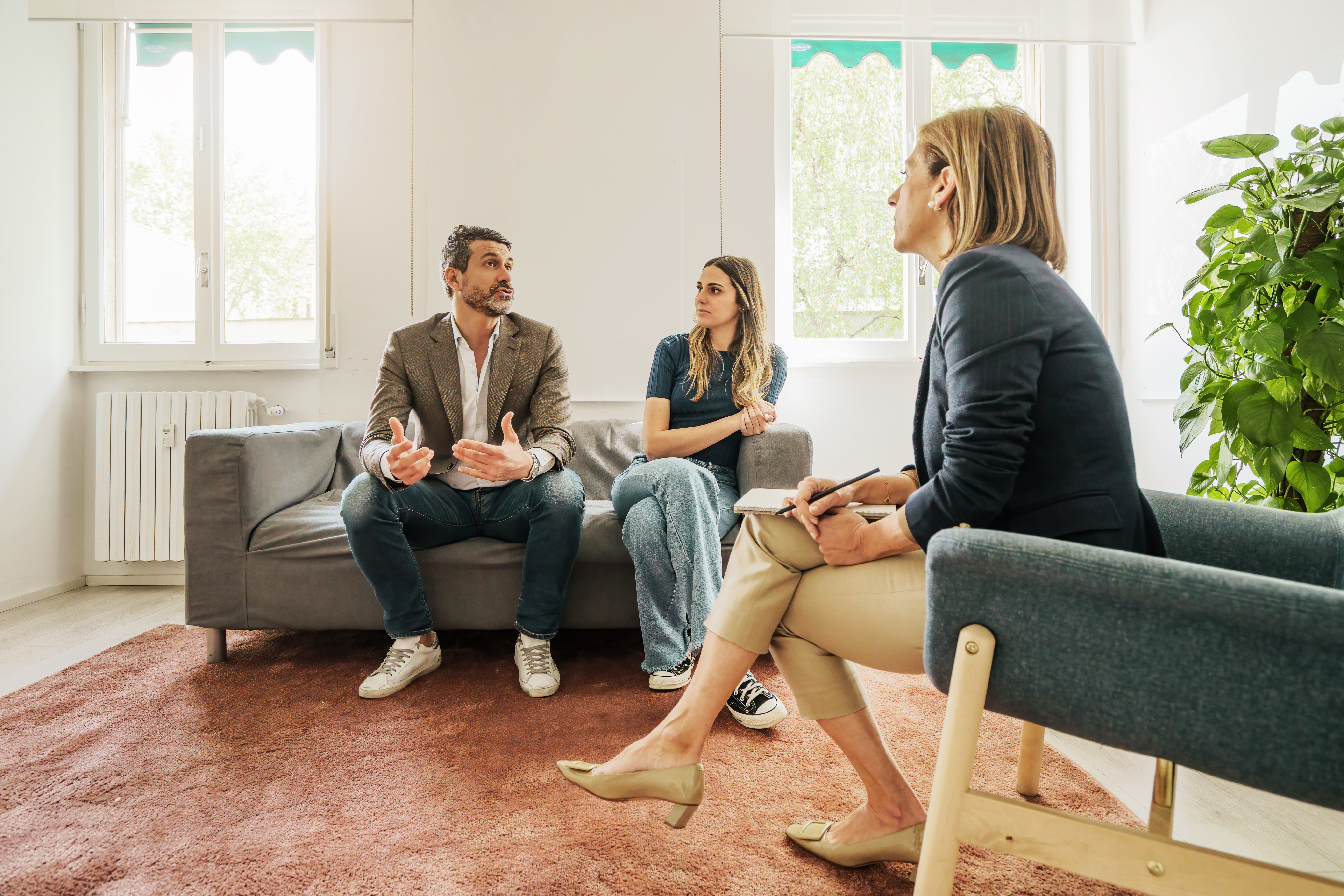 A woman counsels a married couple that is working through difficult conflict.