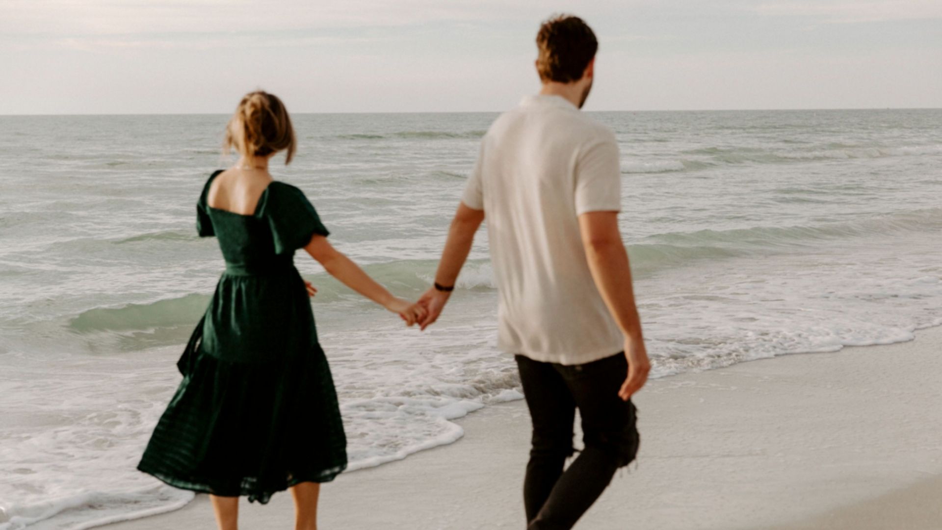 couple holding hands on beach