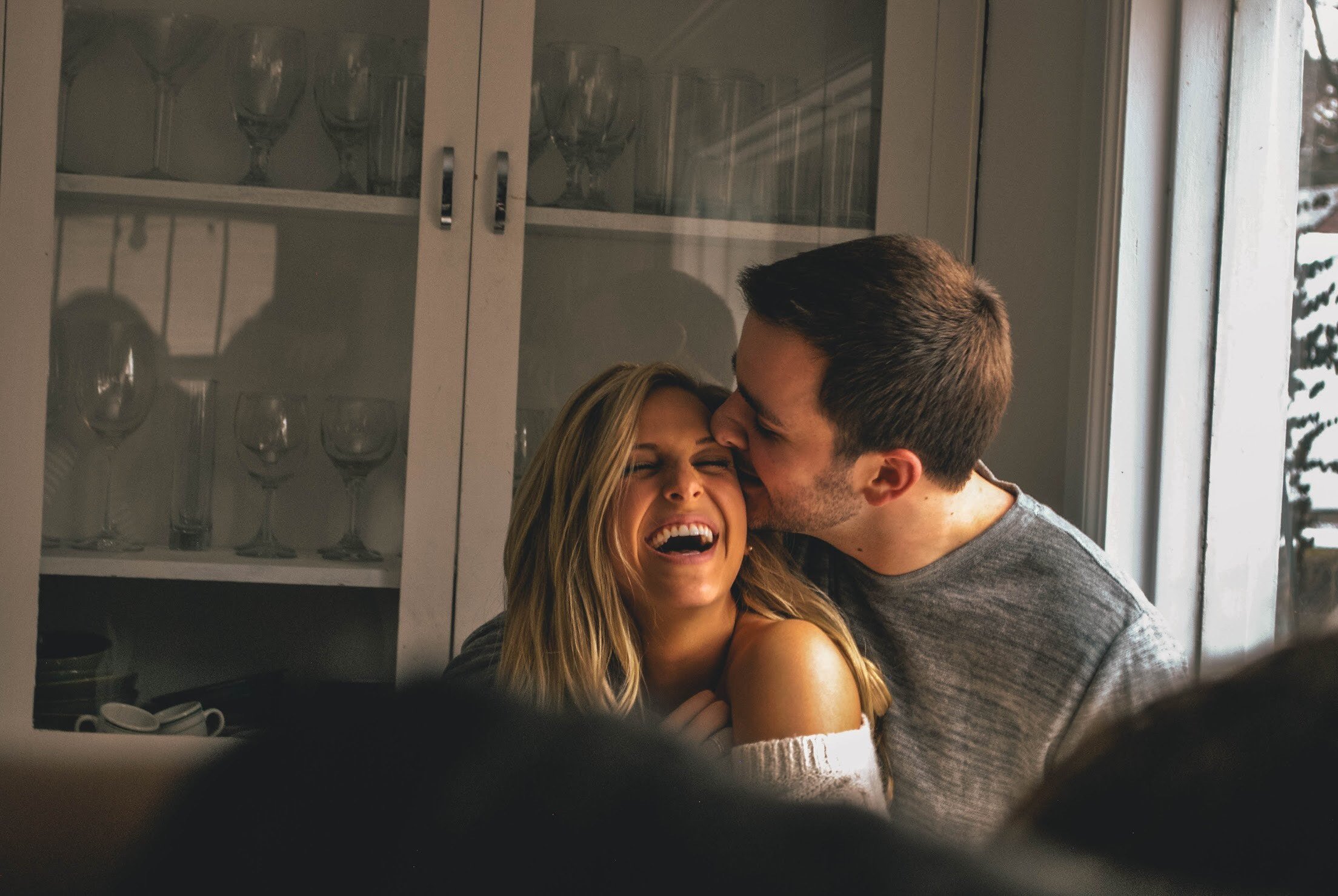 couple hugging and man kissing wife