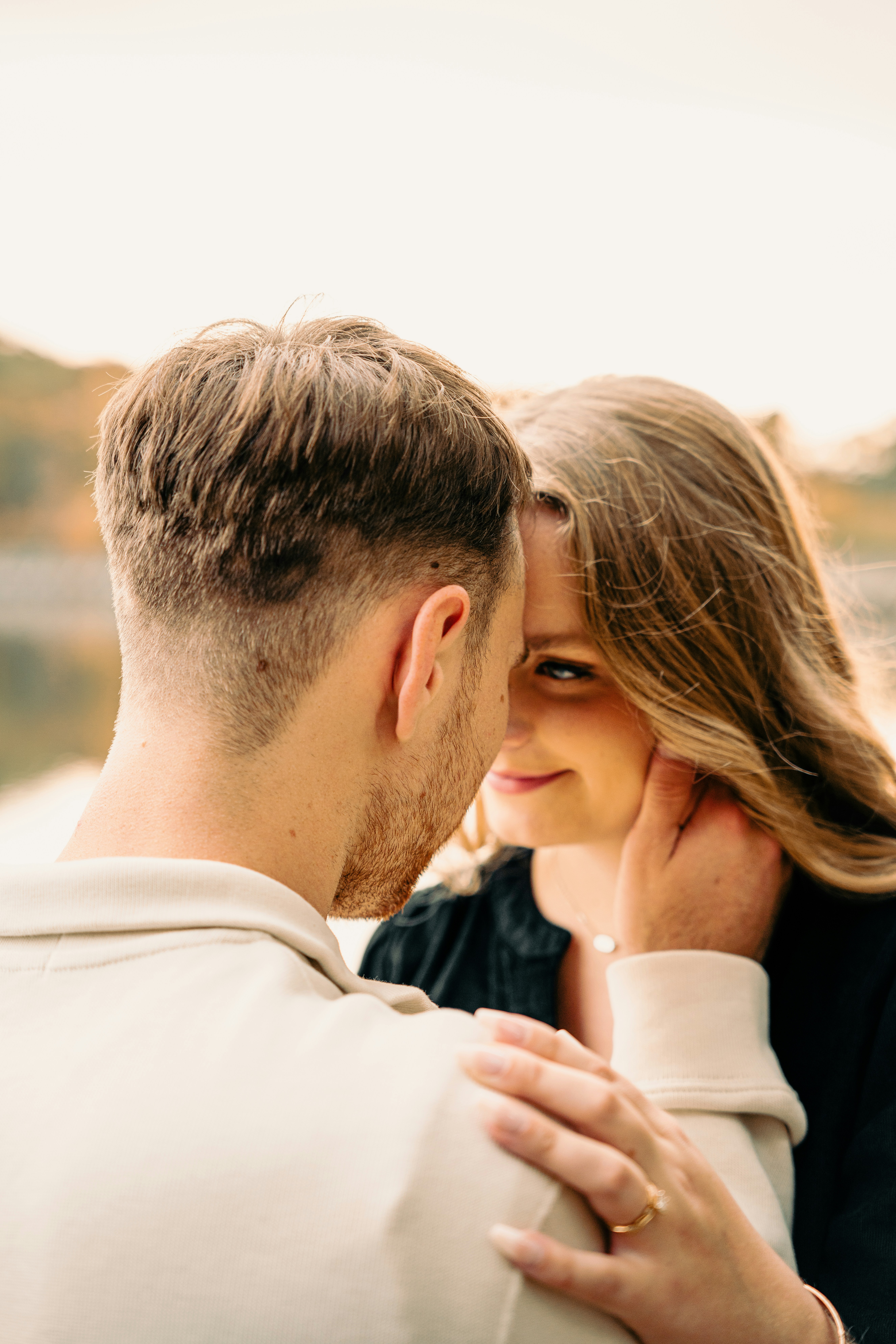 Intimate close-up of a husband gently touching his wife's face as they look lovingly at one another, showcasing an example of emotional intimacy and how to romance your wife.
