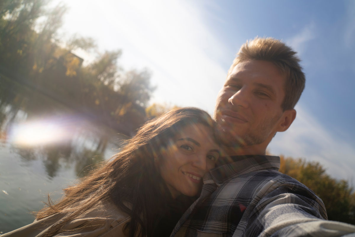 couple selfie by the lake with sun