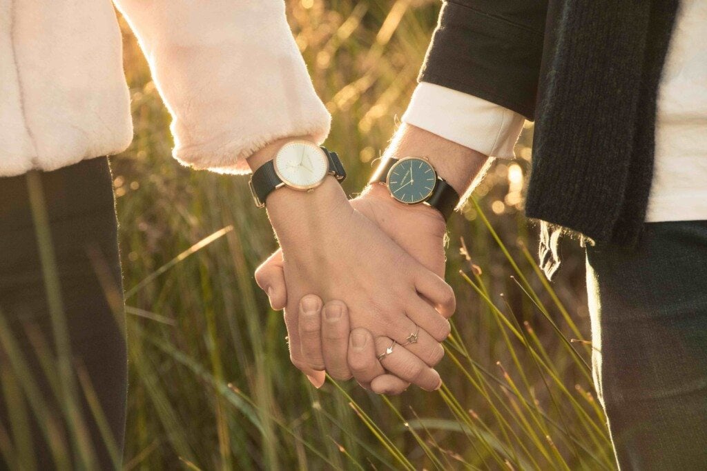 couple holding hands in a field