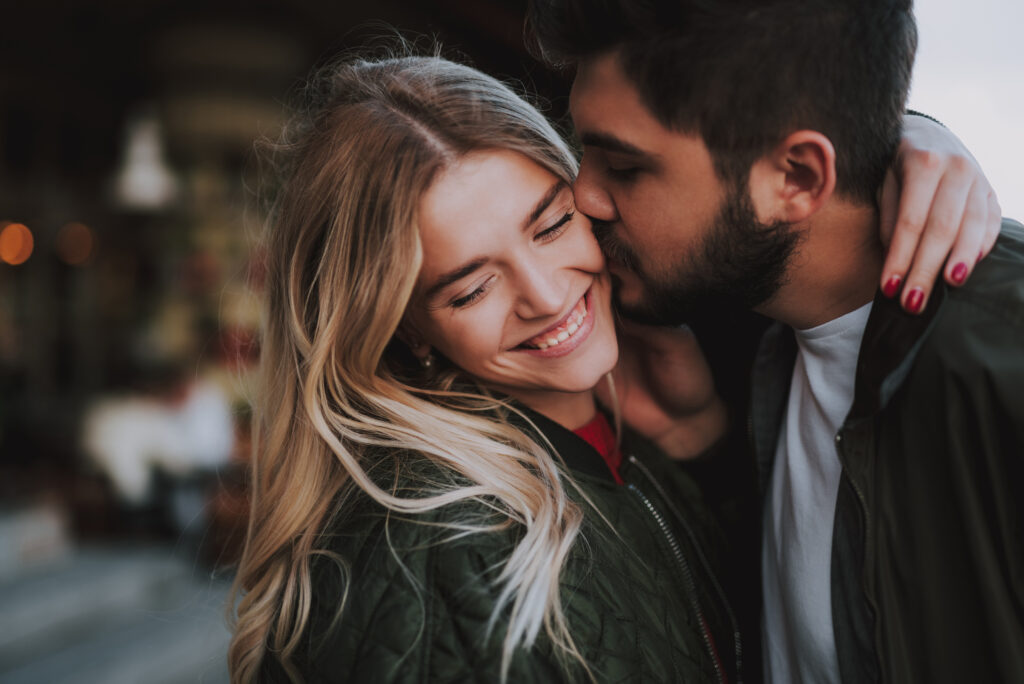man kissing woman on cheek