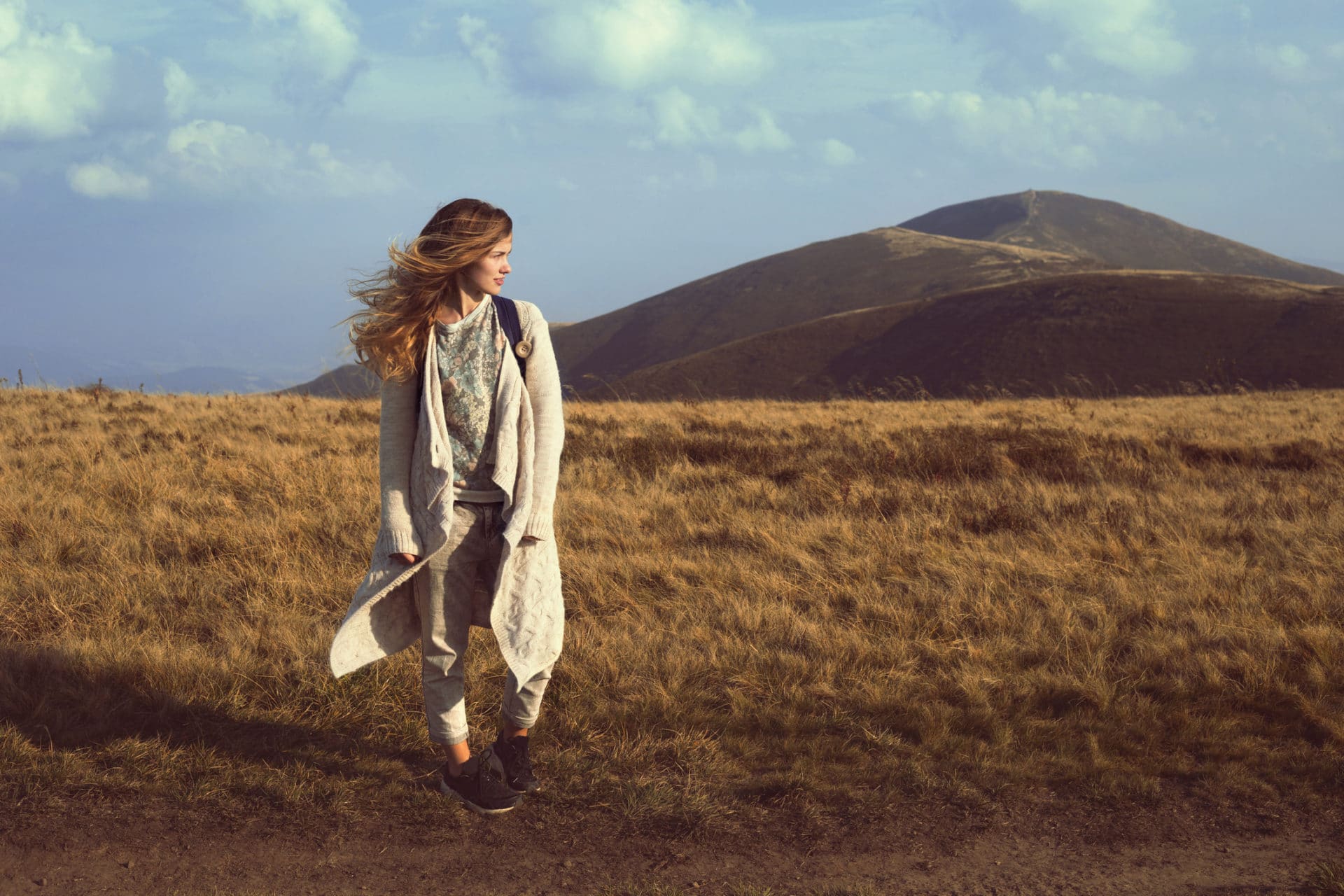 Woman standing in a field looking right