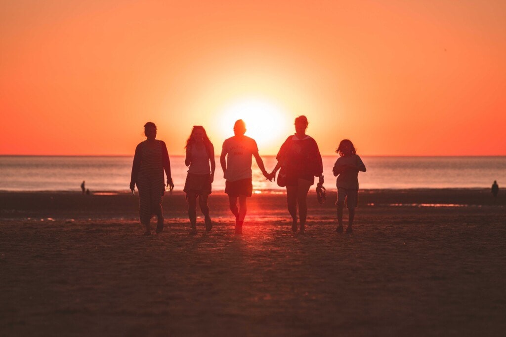 family on a beach at sunset