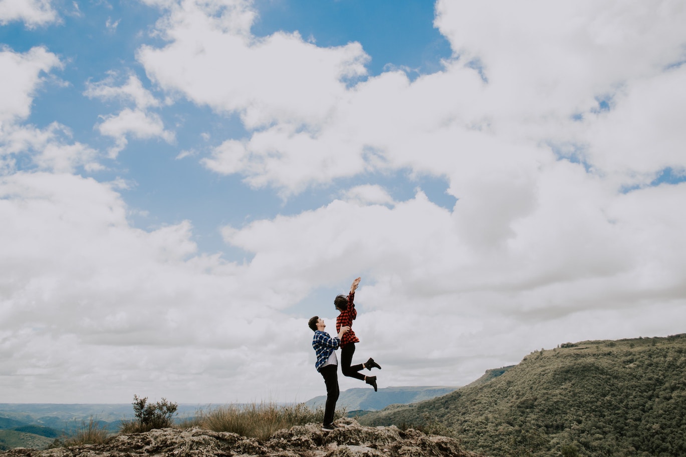 a man holding a woman jumping