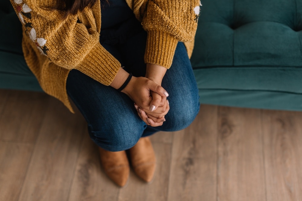woman sitting holding her hands